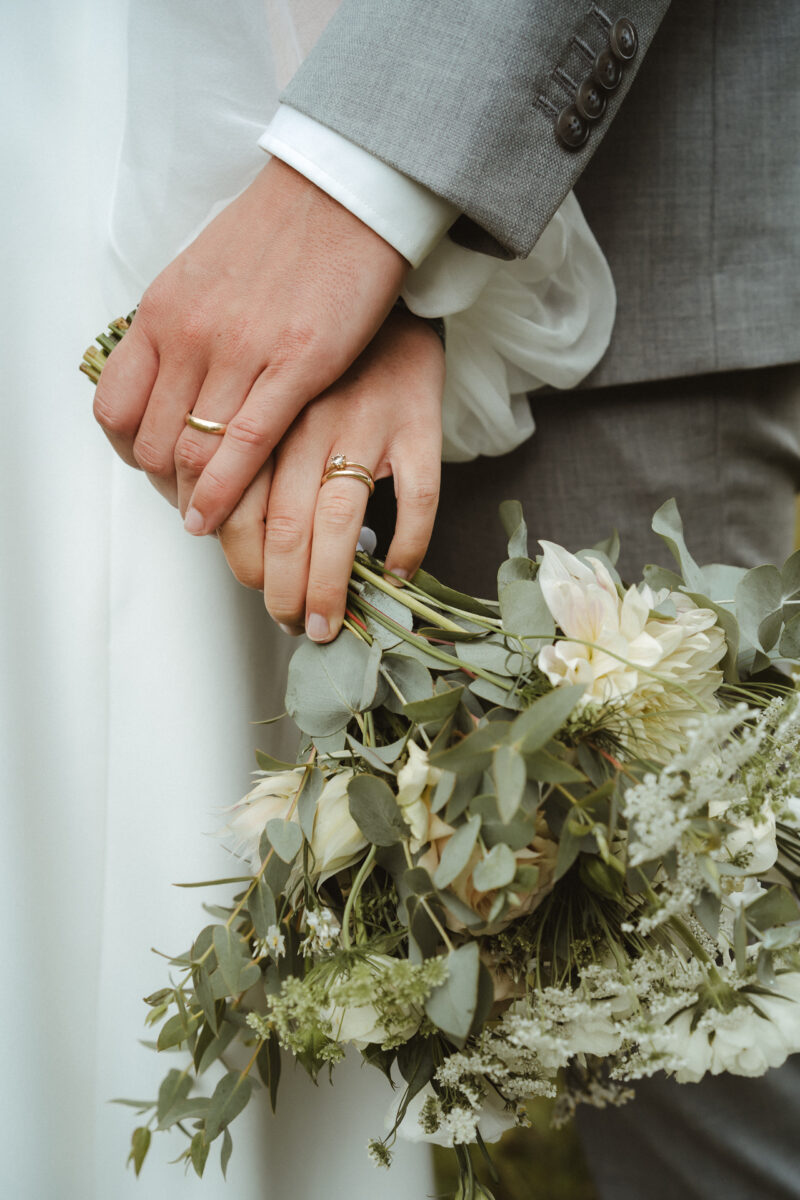 Detailaufnahme von den H&auml;nden eines Brautpaares mit Ringen und Brautstrau&szlig; - Hochzeitsfotografie Erkelenz