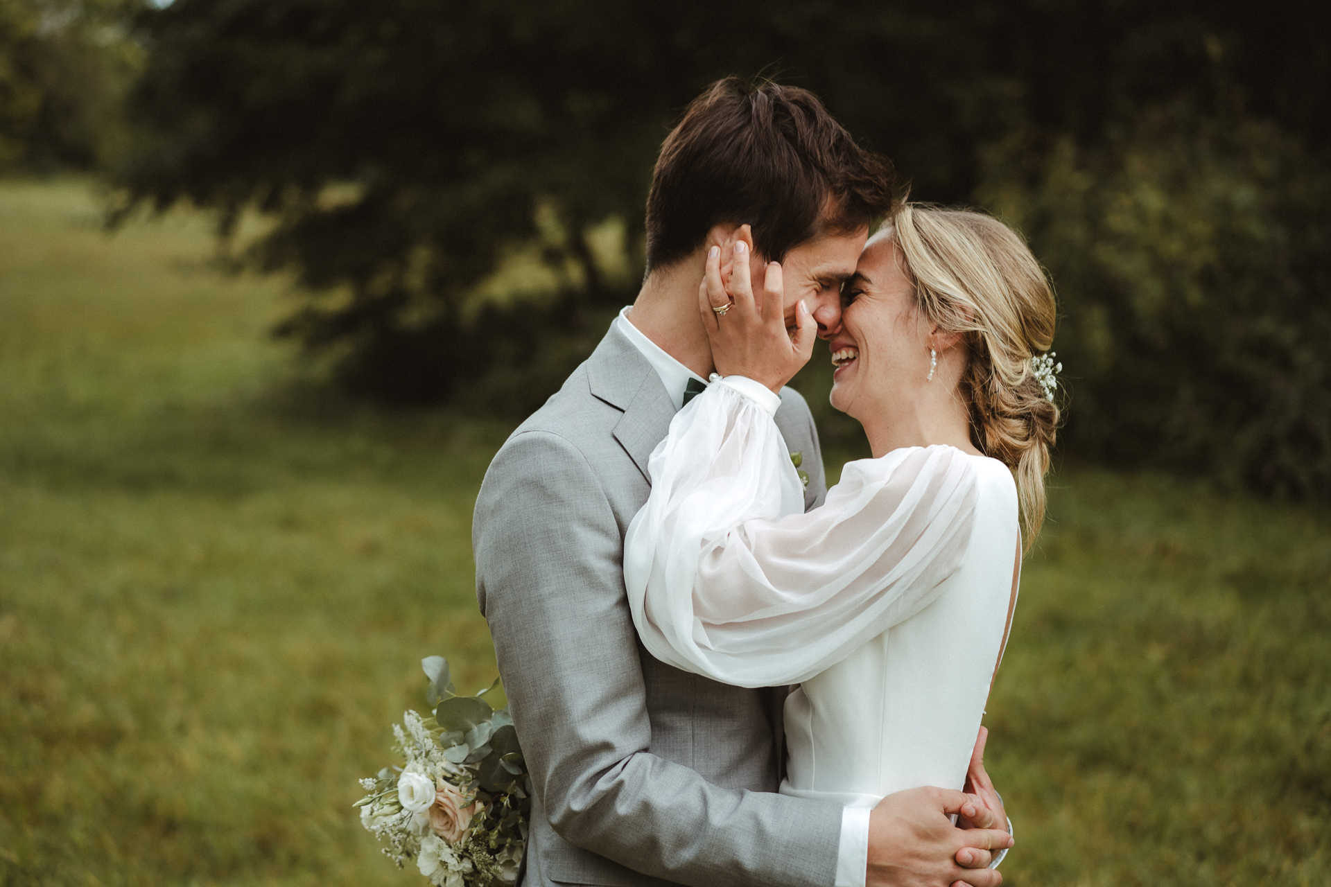 Brautpaar küsst sich zärtlich auf einer grünen Wiese - Hochzeitsfotograf Aachen