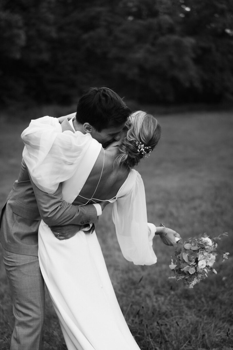 Bräutigam lehnt seine Braut nach hinten und flüstert Ihr etwas in Ohr - Hochzeit Düsseldorf Fotograf