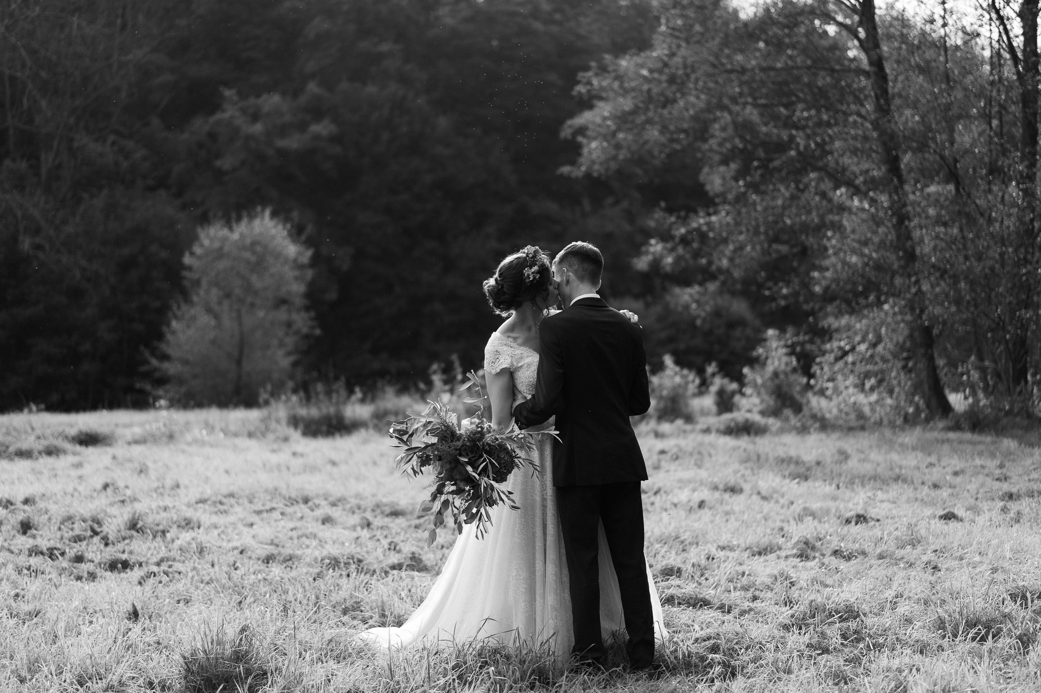 Brautpaar steht auf einer Wiese und küsst sich - Hochzeitsfotograf Erkelenz