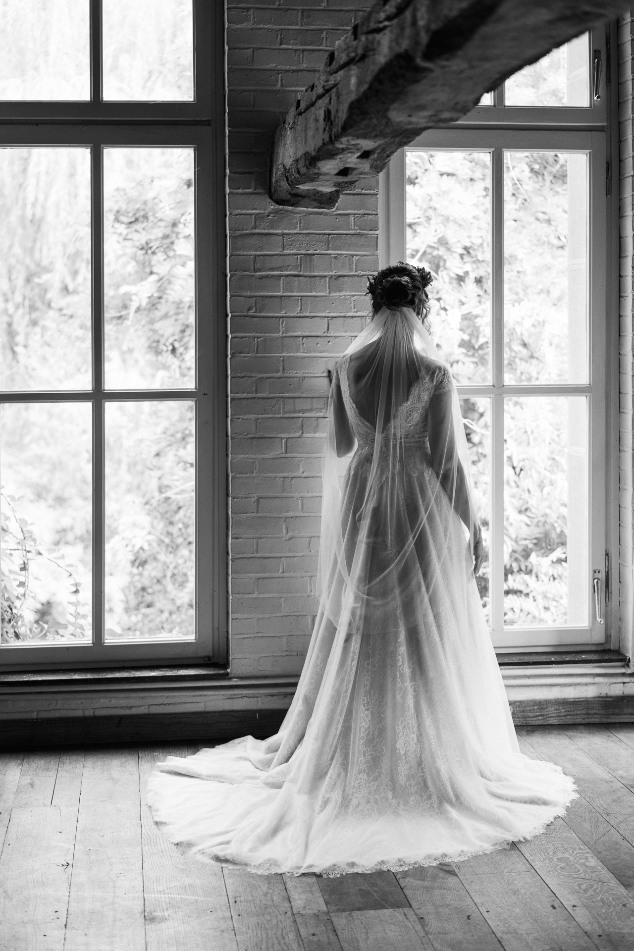 Braut steht mit dem Rücken zur Kamera und schaut aus dem Fenster - Hochzeitsfotograf Erkelenz
