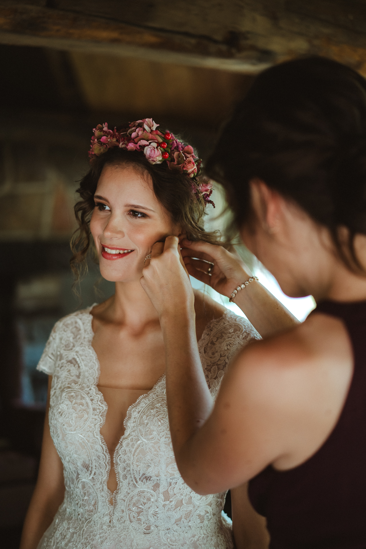 Braut bekommt beim Getting Ready ihre Ohringe angesteckt und lächelt in die Kamera - Hochzeitsfotos Erkelenz Hochzeitsfotograf