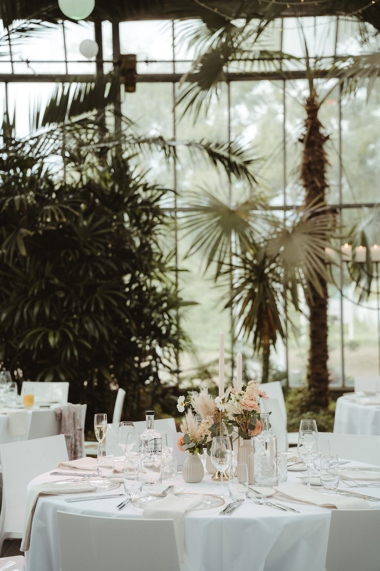 Hochzeitstisch schön geschmückt mit Blumen und Gläsern mit weißer Tischdecke - Detailfotografie auf einer Hochzeit in der Blumenhalle Jülich