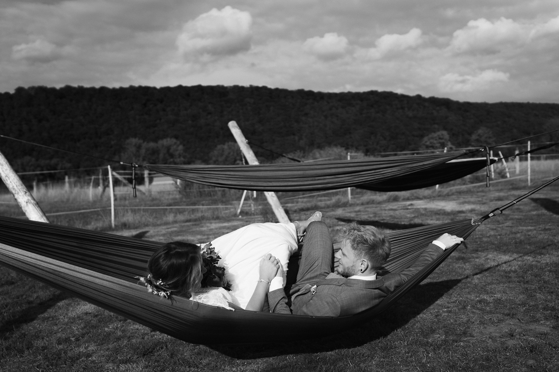 Brautpaar sitzt in einer Hängematte und lächelt sich an - Hochzeitsreportage Aachen