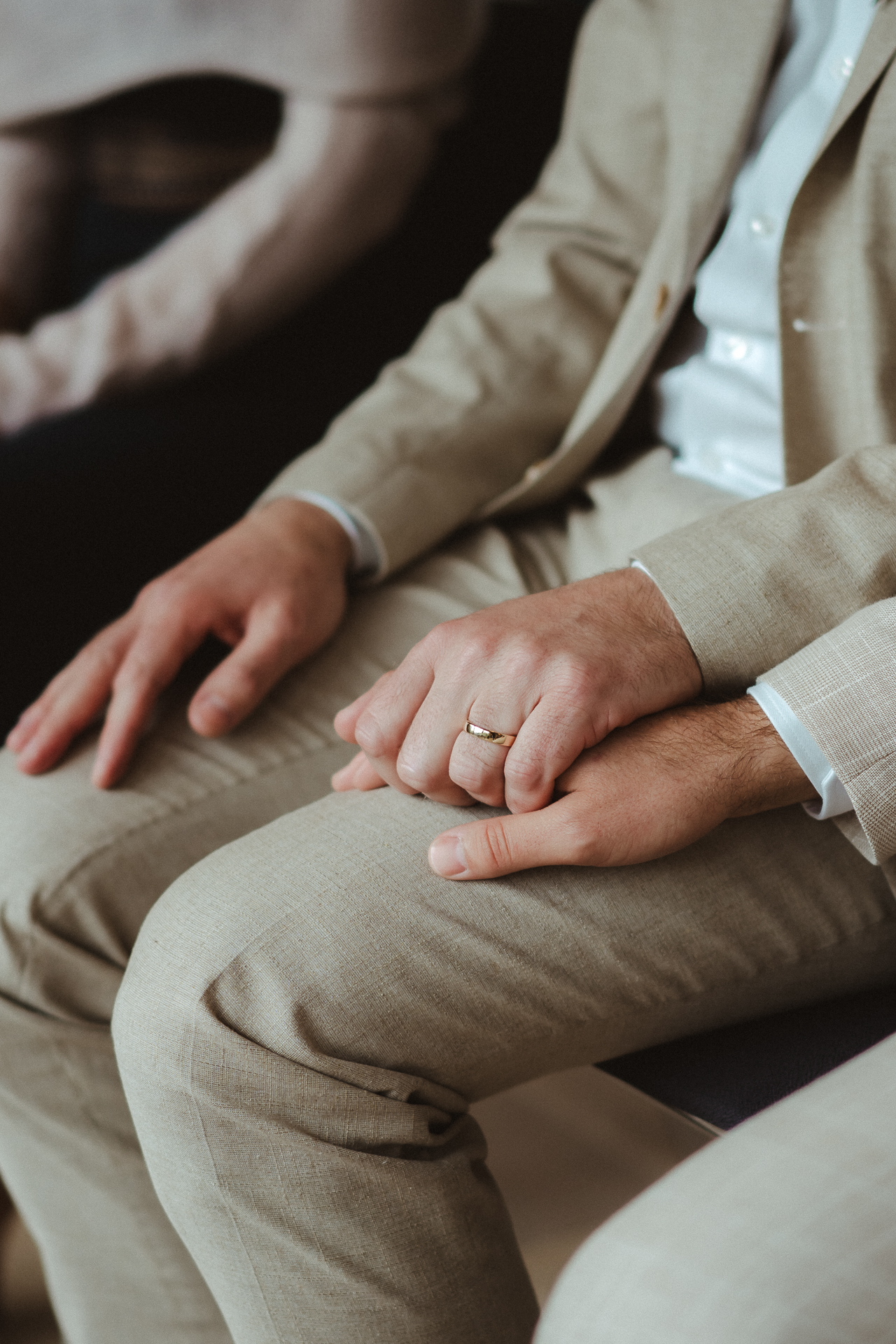 Detailfoto von den Händen des Brautpaares - goldener Ring im Fokus