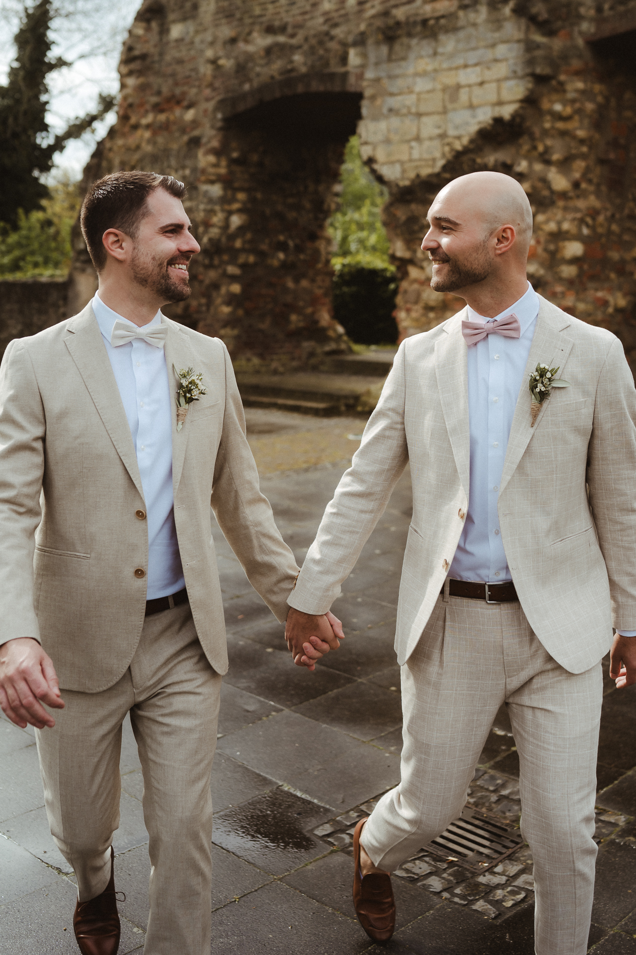 Brautpaar lächelt sich an und läuft auf die Kamera zu - Paarshooting Heinsberg