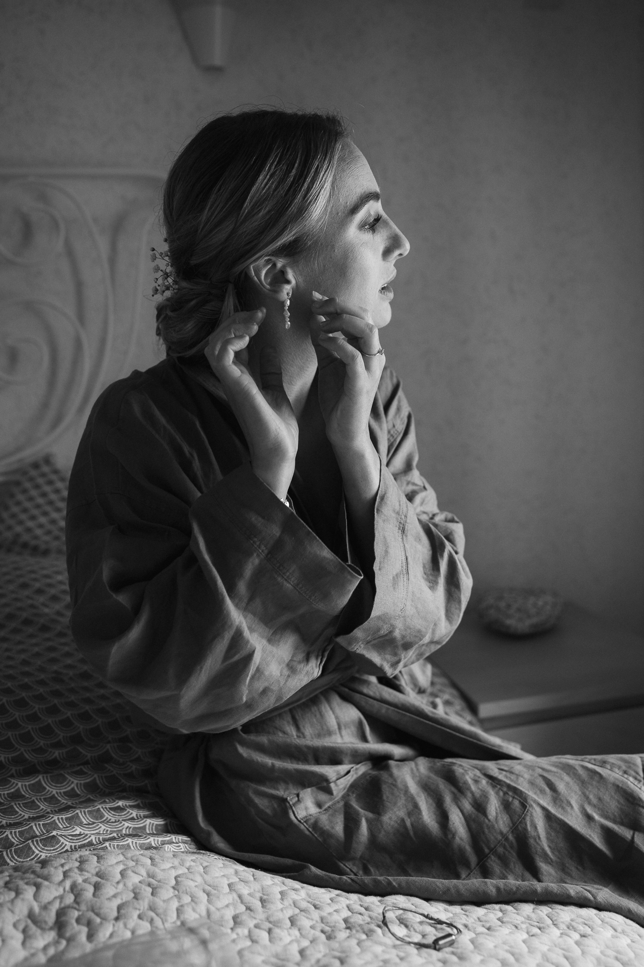 Braut steckt sich einen Ohrring an, die letzten Vorbereitungen im Hotelzimmer beim Getting Ready - authentische Hochzeitsfotografie Erkelenz