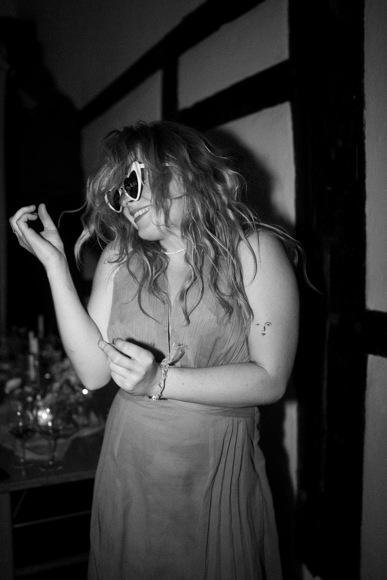 Hochzeitsgast tanzt ausgelassen mir einer weißen Herzbrille auf - Partyfotos Hochzeit