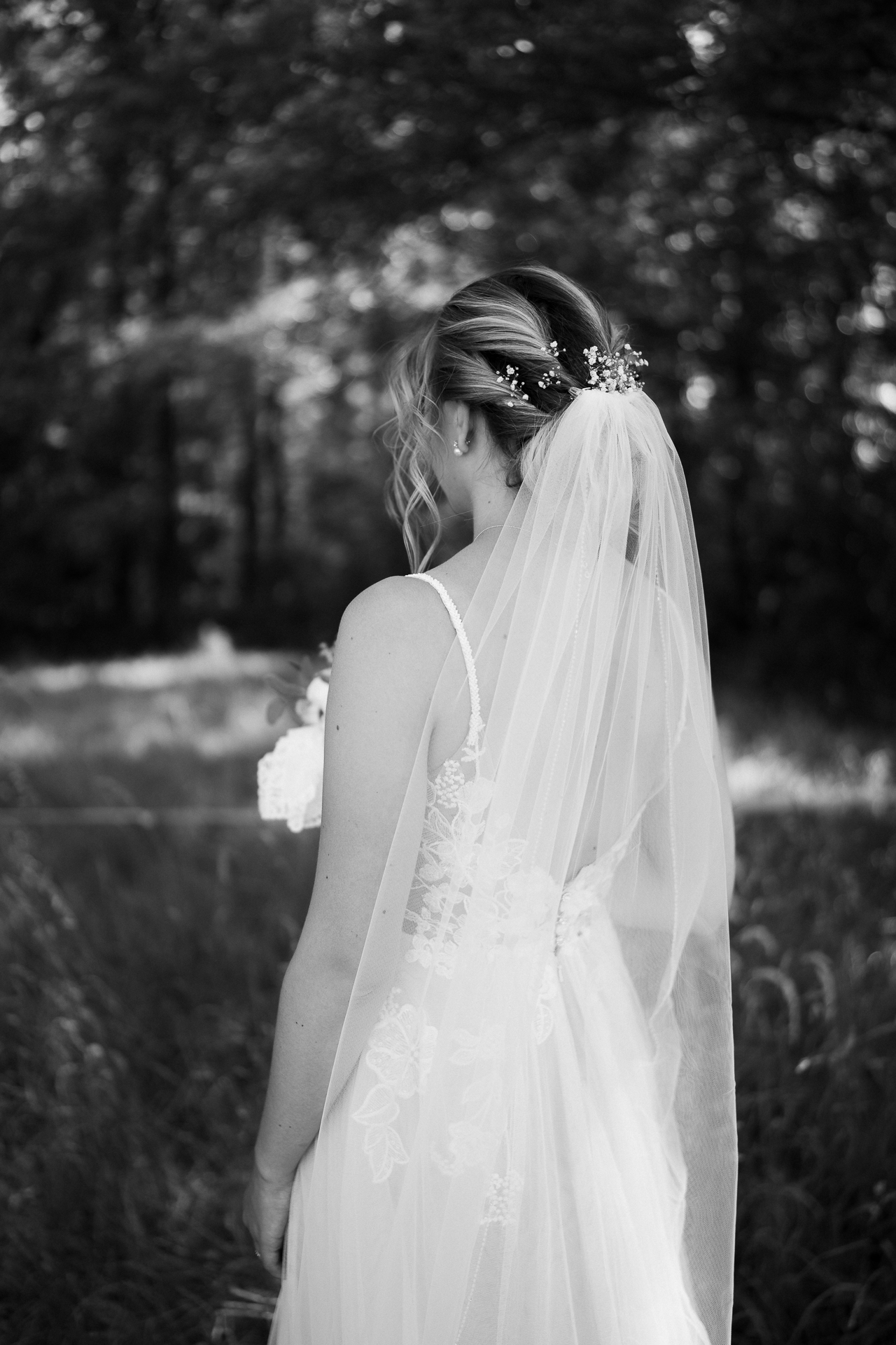 Detailfoto der Braut vom Rücken, Hochgesteckten Haaren und einem sanft fallenden Schleier - Hochzeitsfotografie Erkelenz