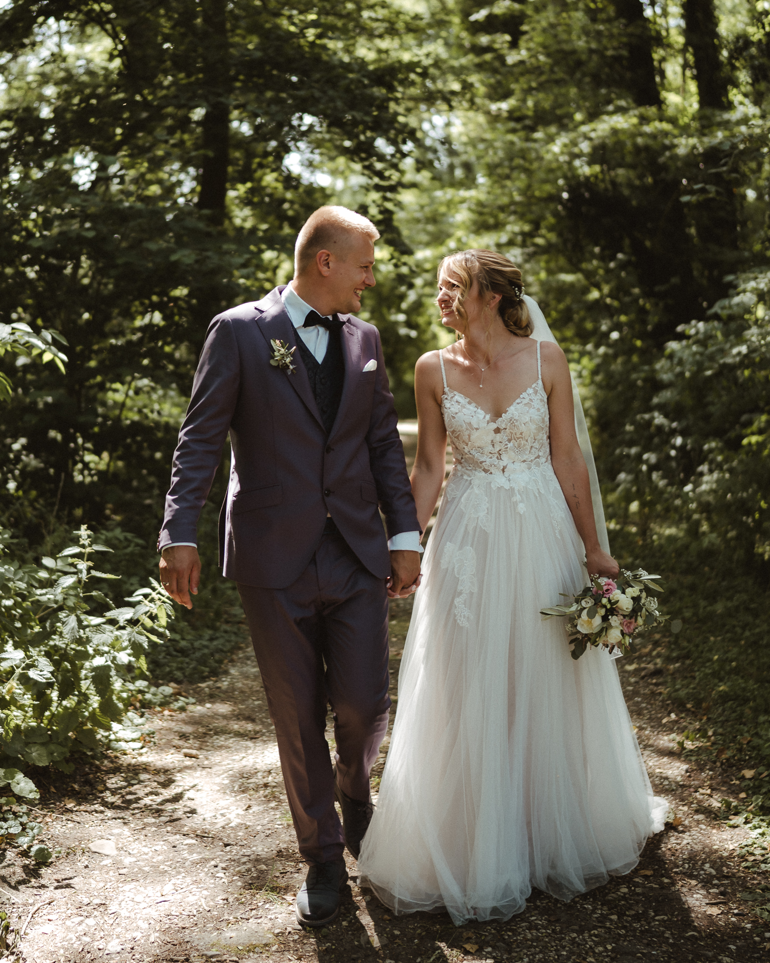 Brautpaar läuft Hand in Hand durch den Wald - emotionale Hochzeitsfotos Erkelenz