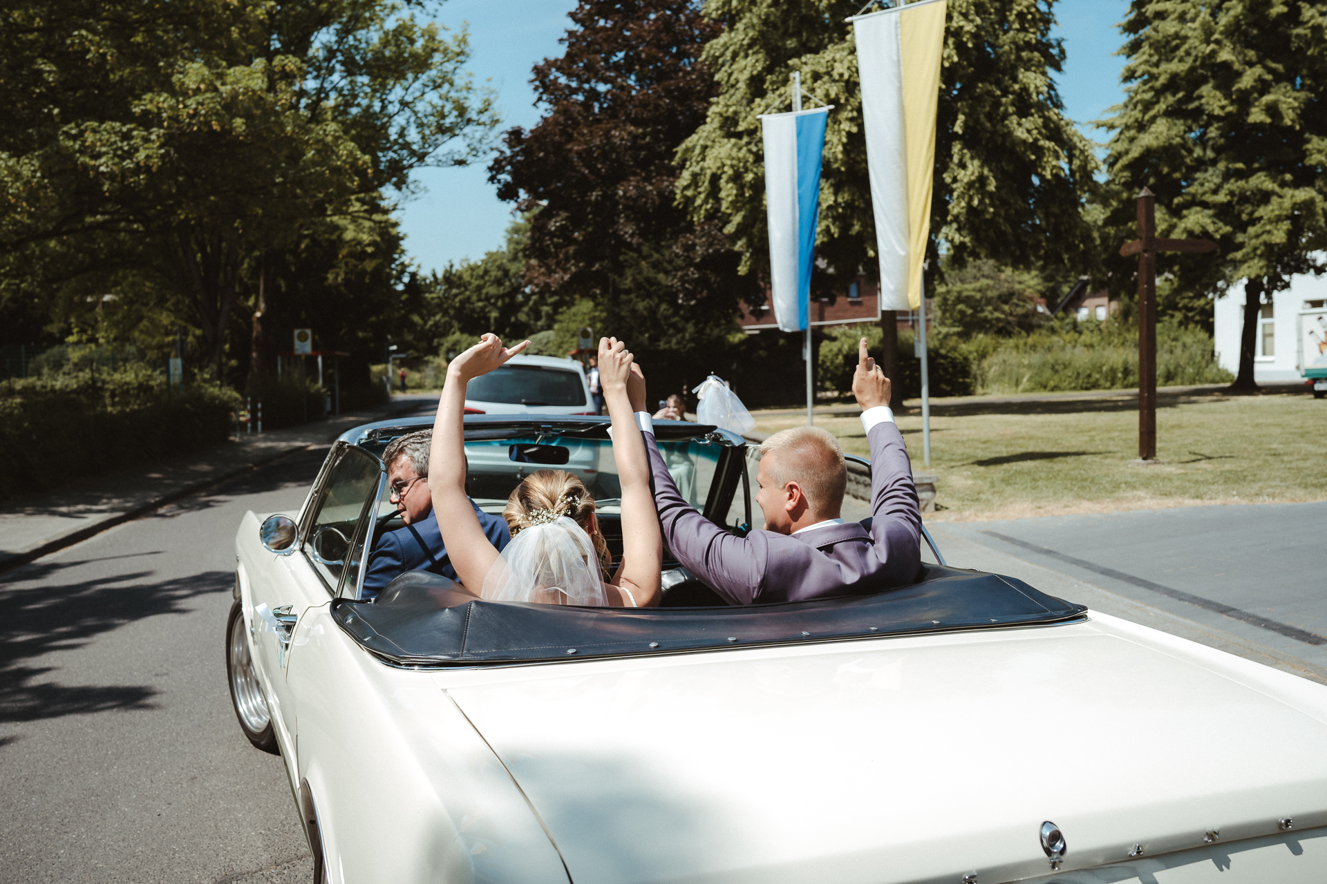 Brautpaar sitzt im Hochzeitsauto und jubelt - Fotograf Hochzeit Erkelenz