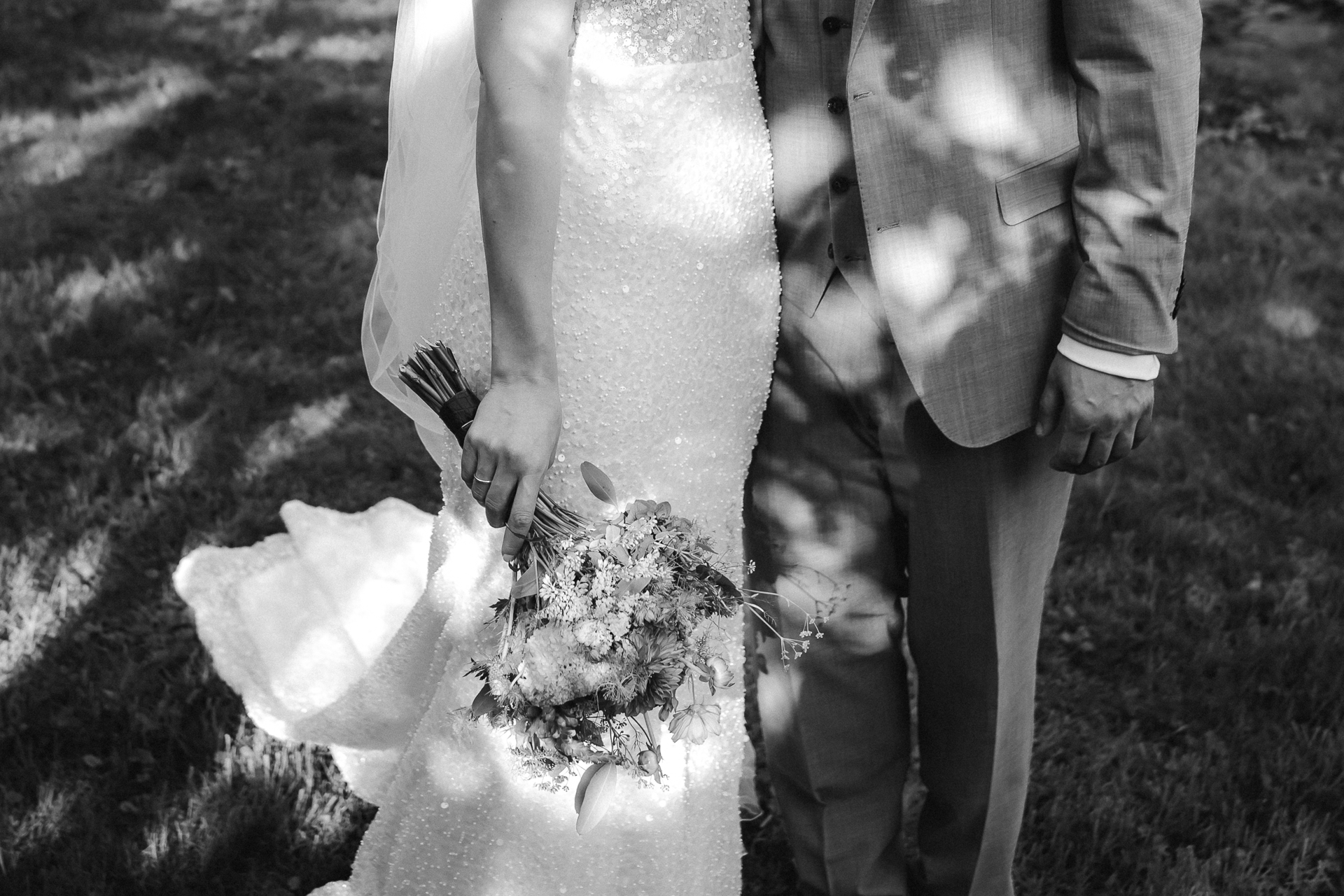 Foto vom Kleid der Braut und Anzug des Bräutigam. Beide stehen auf einer schattigen Wiese - Hochzeitsfotos aus Erkelenz