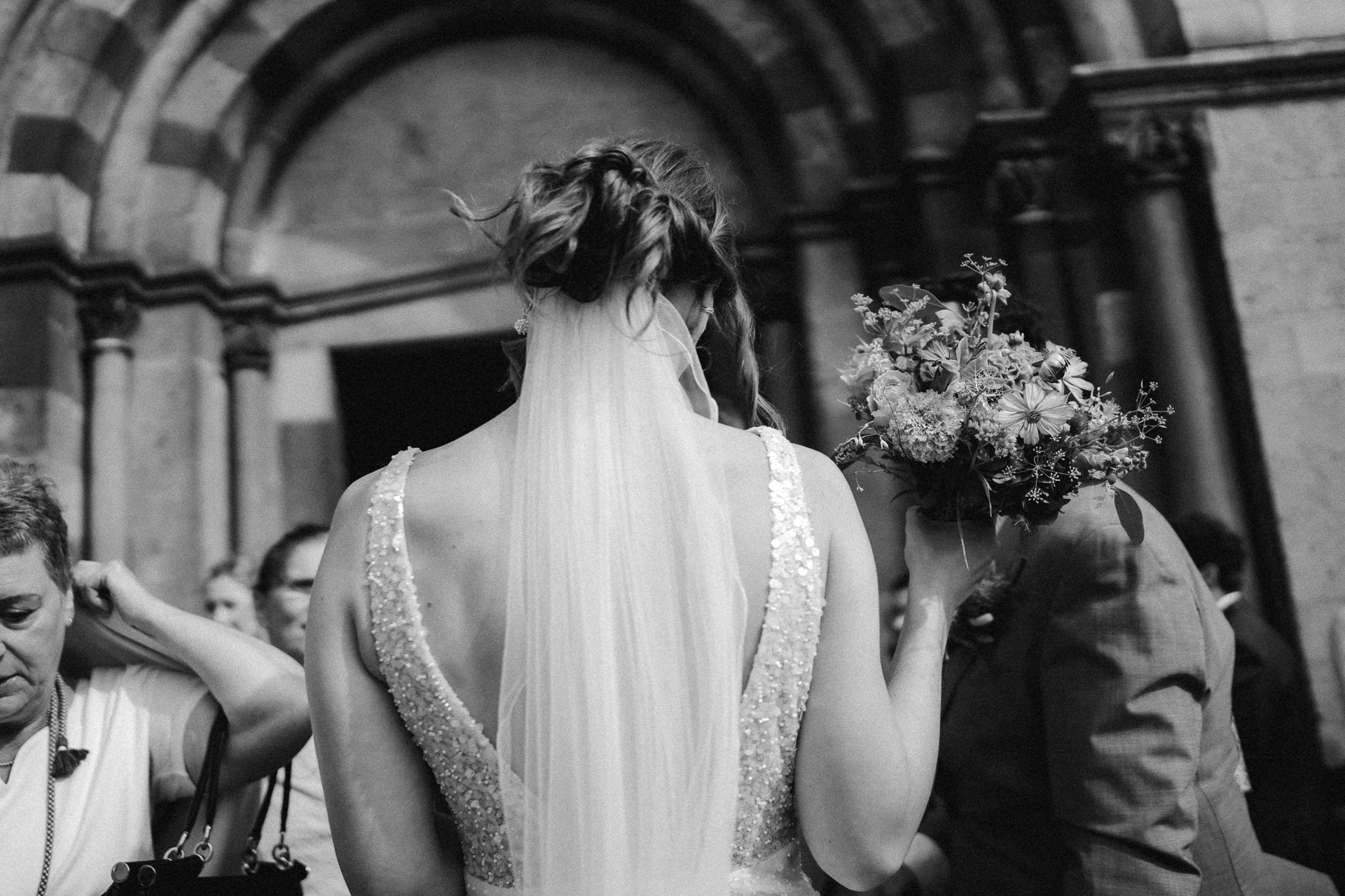 Detailfoto von einer Braut - Hochzeitsstrauß, Schleier und schöne hochgesteckte Haare