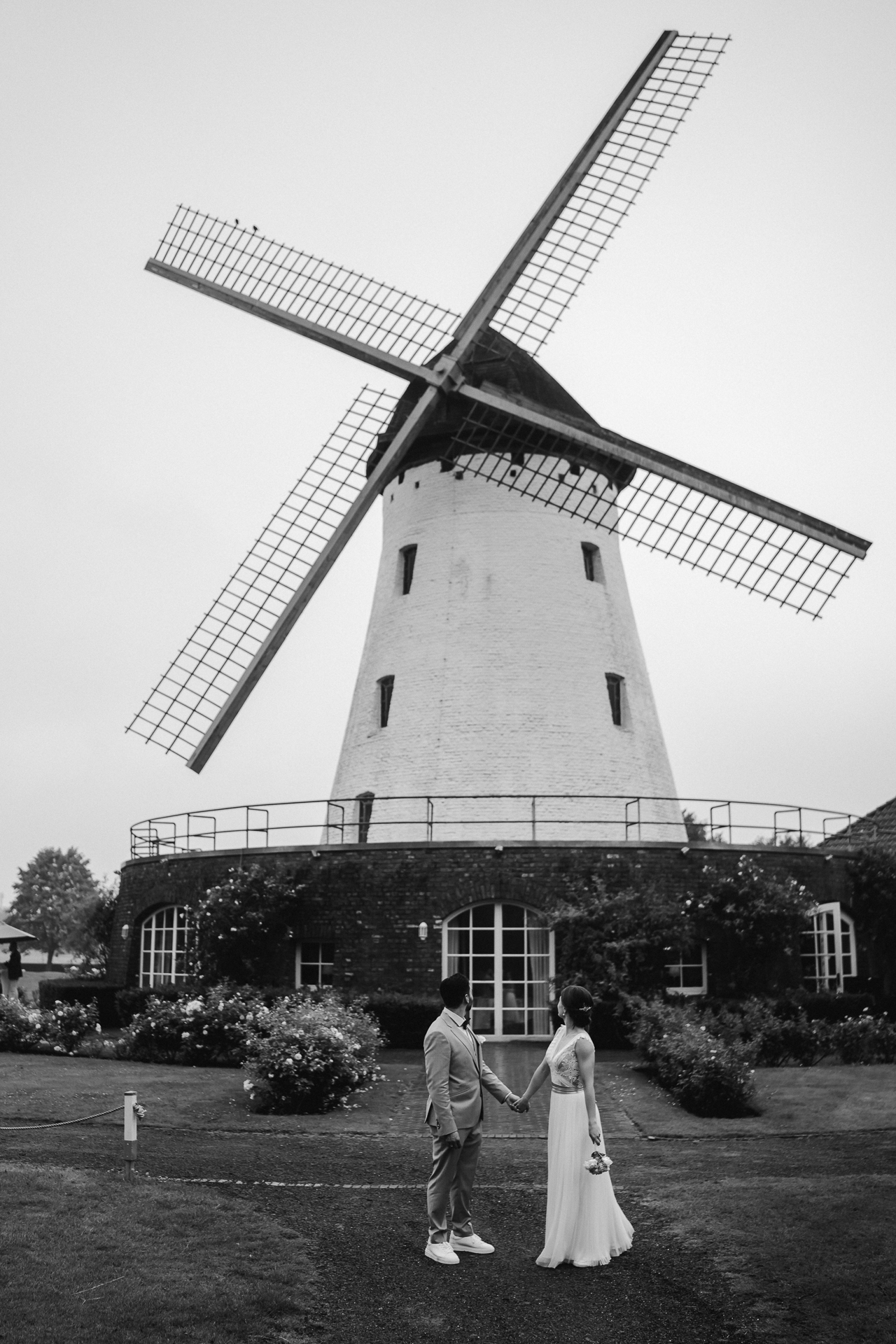 Brautpaar steht vor einer alten Mühle und hält sich an der Hand - Hochzeitsbilder aus Aachen