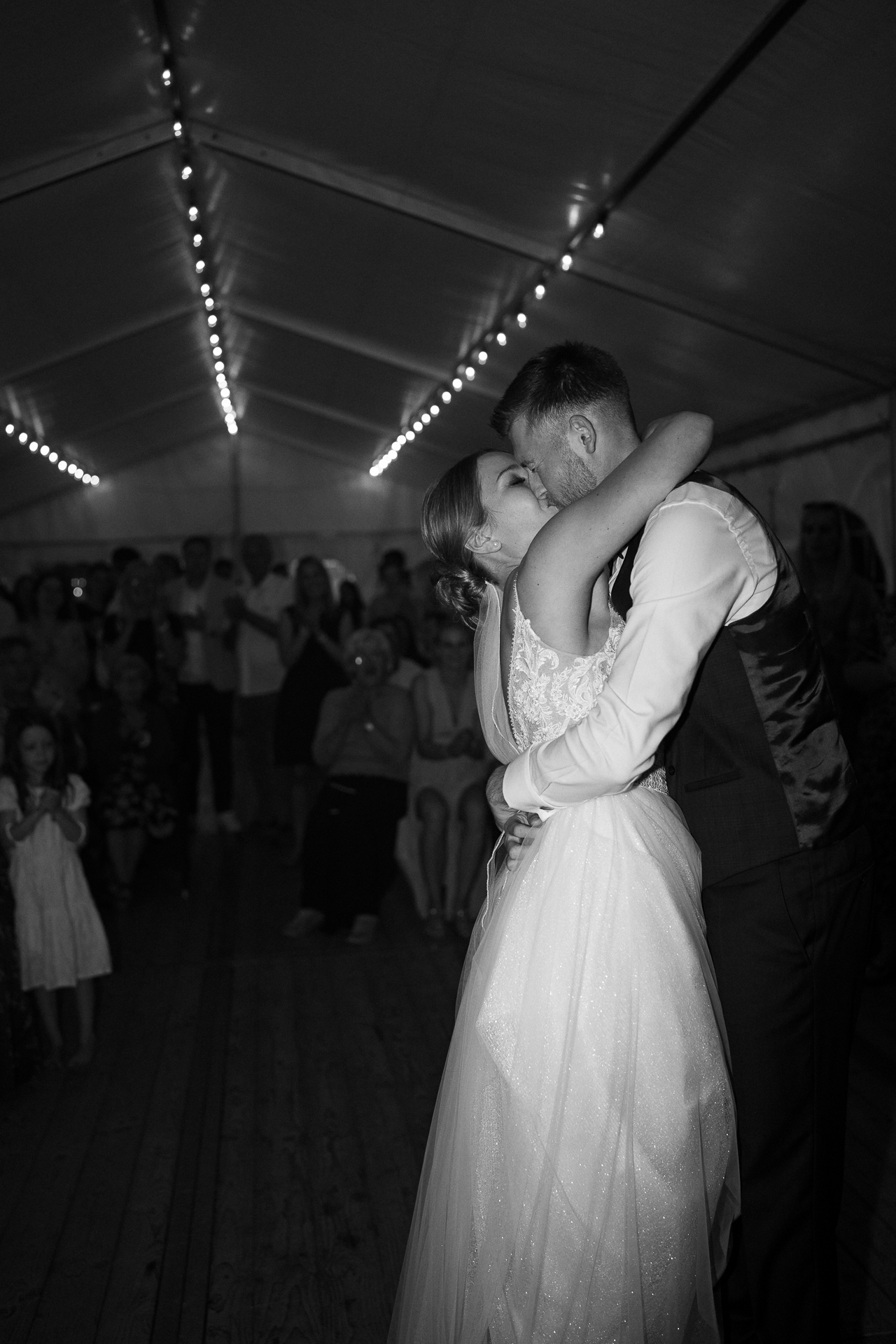 Bräutigram und Braut fallen sich nach dem Hochzeitstanz in die Arme und küssen sich - romantische Hochzeitsfotografie Erkelenz