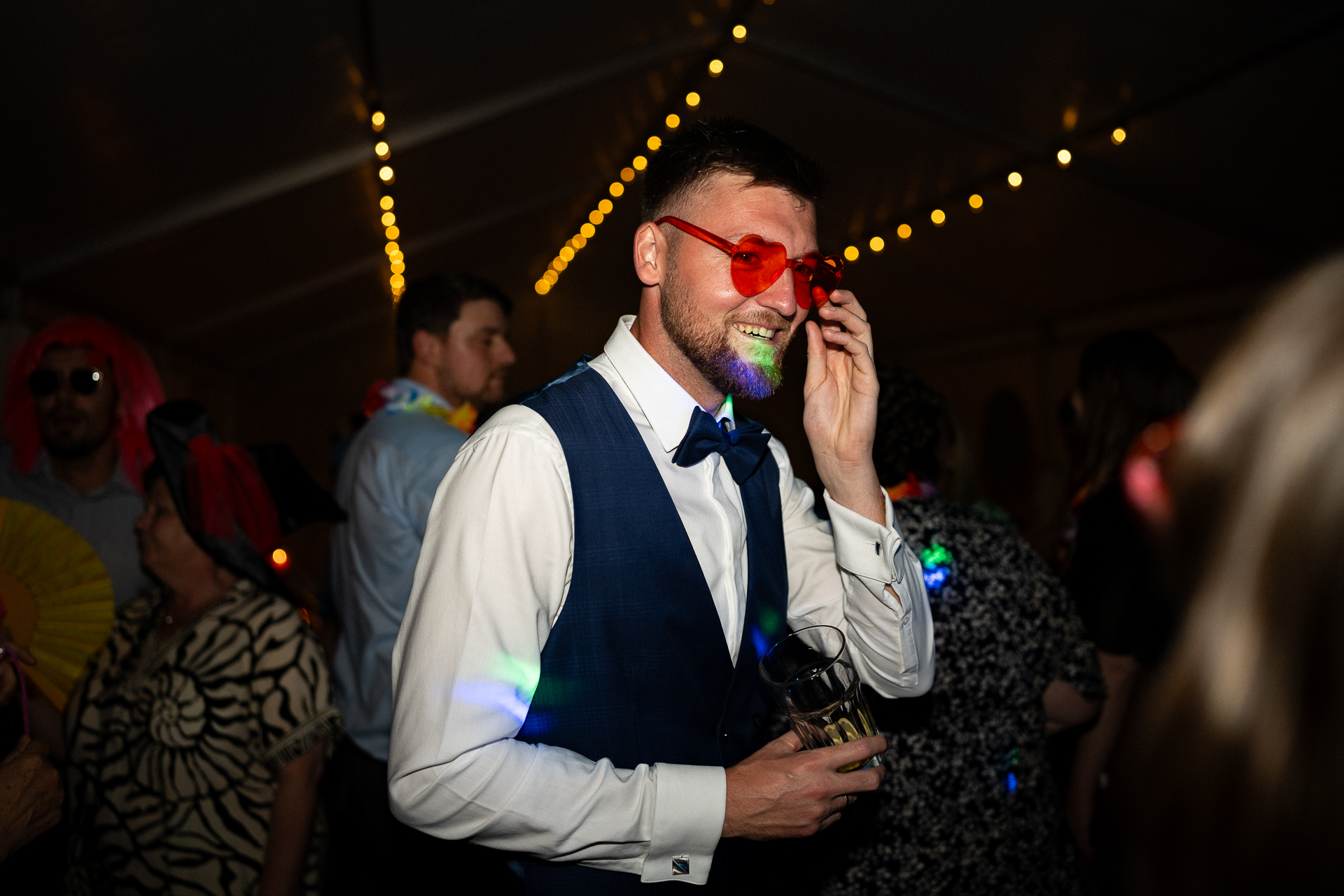 Bräutigam hat eine rote Herzbrille auf - Partyfoto auf einer Hochzeit